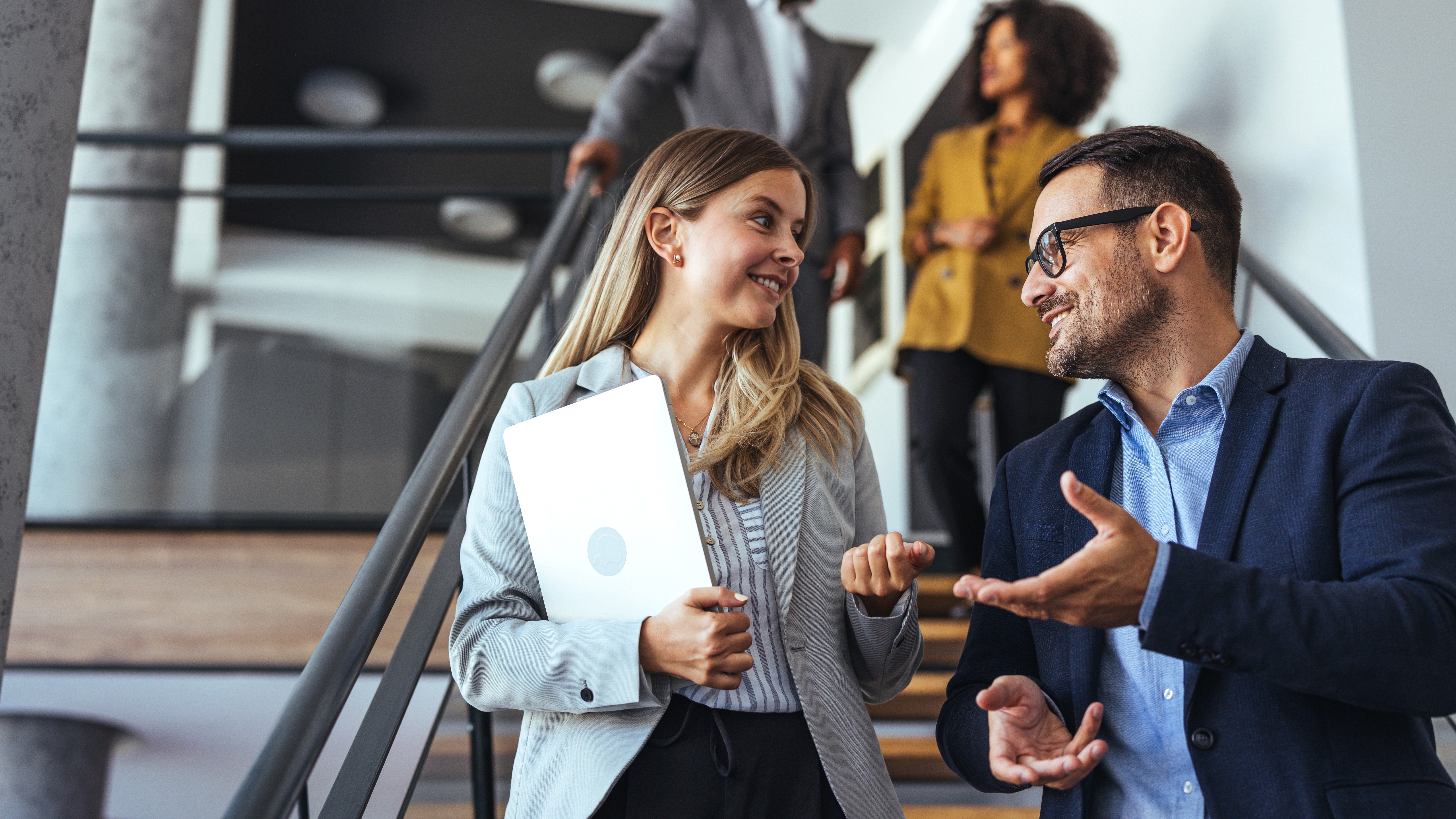 Colleagues Engaging in a Pleasant Discussion on Office Staircase