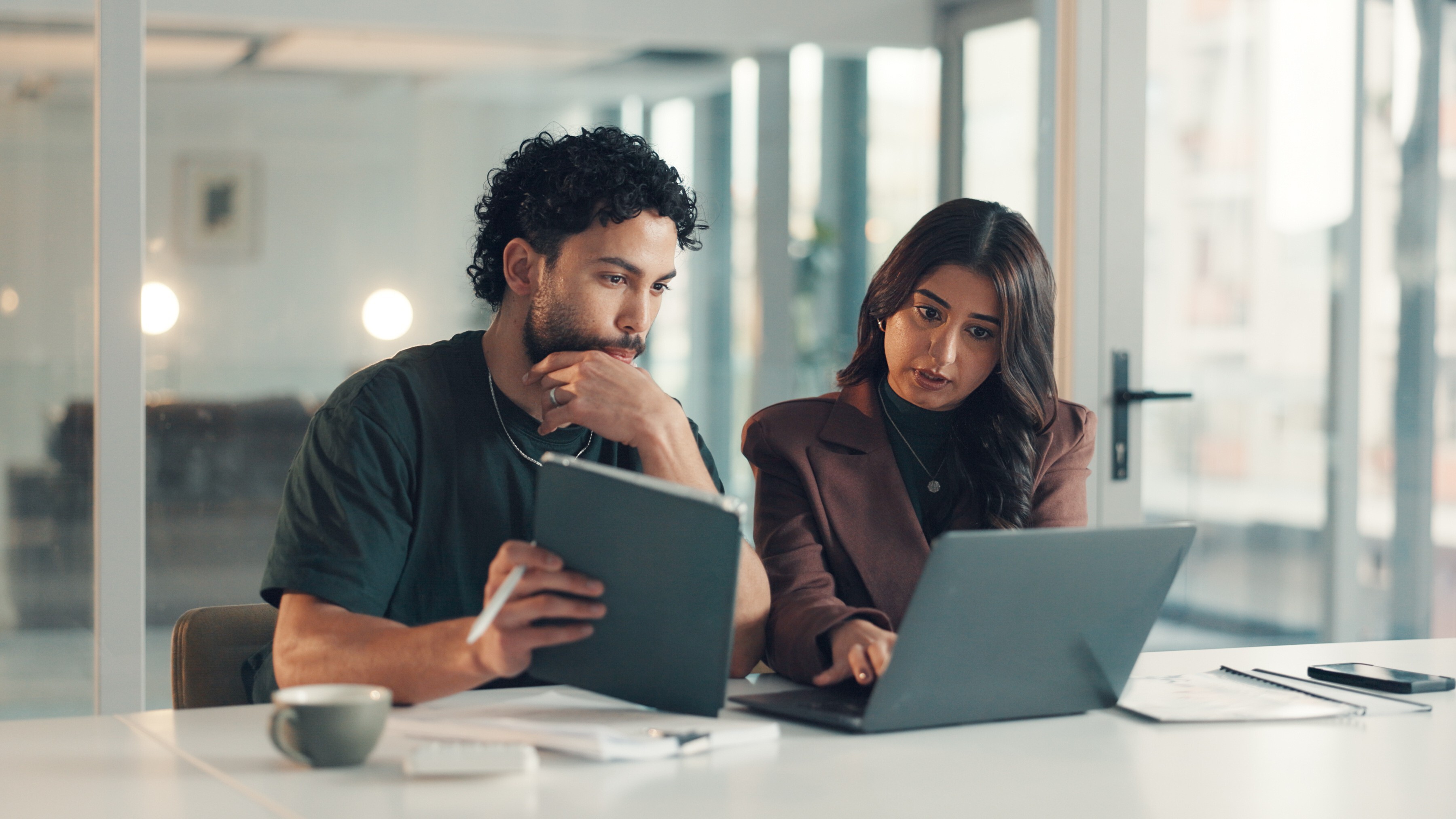 Business, problem solving or tech support with man and woman in office together for troubleshooting. Help, meeting or tablet with employee and IT professional in workplace for network maintenance