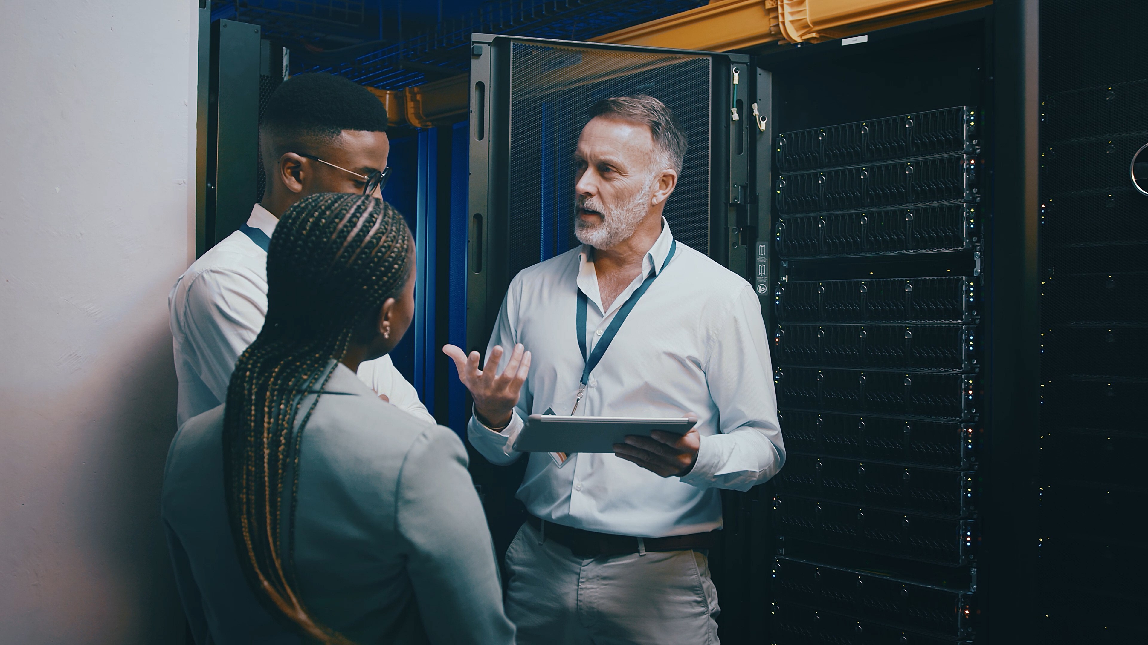 Server room, training and manager with people on tablet for cybersecurity, diagnostics test and maintenance. IT team, meeting and worker with boss for network, online database and technical support