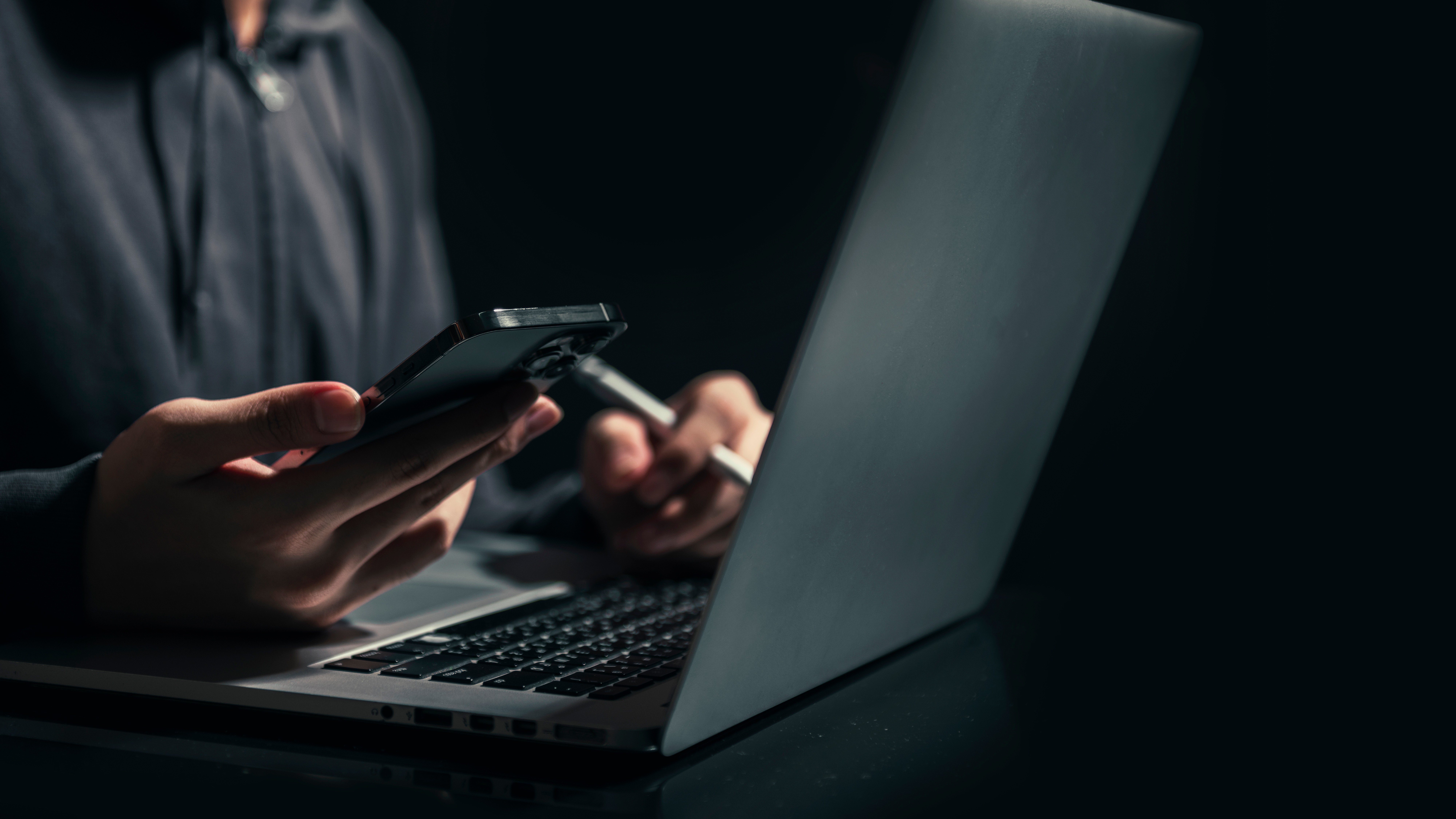 Businessman is working on Smartphone and Laptop. stock business or work from home concept. dark tone