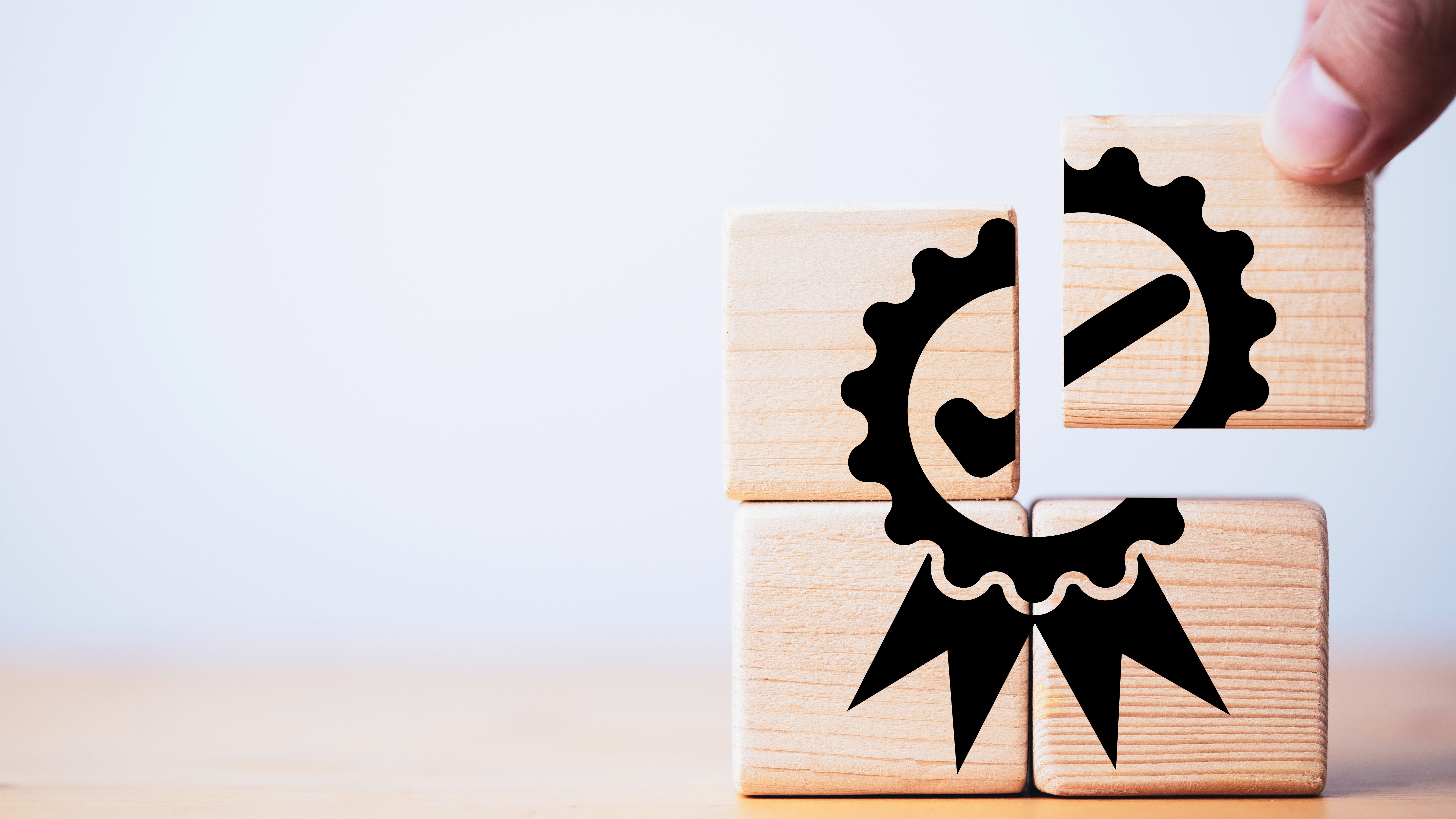 Closeup of hand putting to assemble quality assurance icon which print screen on wooden cube block for quality guarantee and ISO certificate of product and service concept.