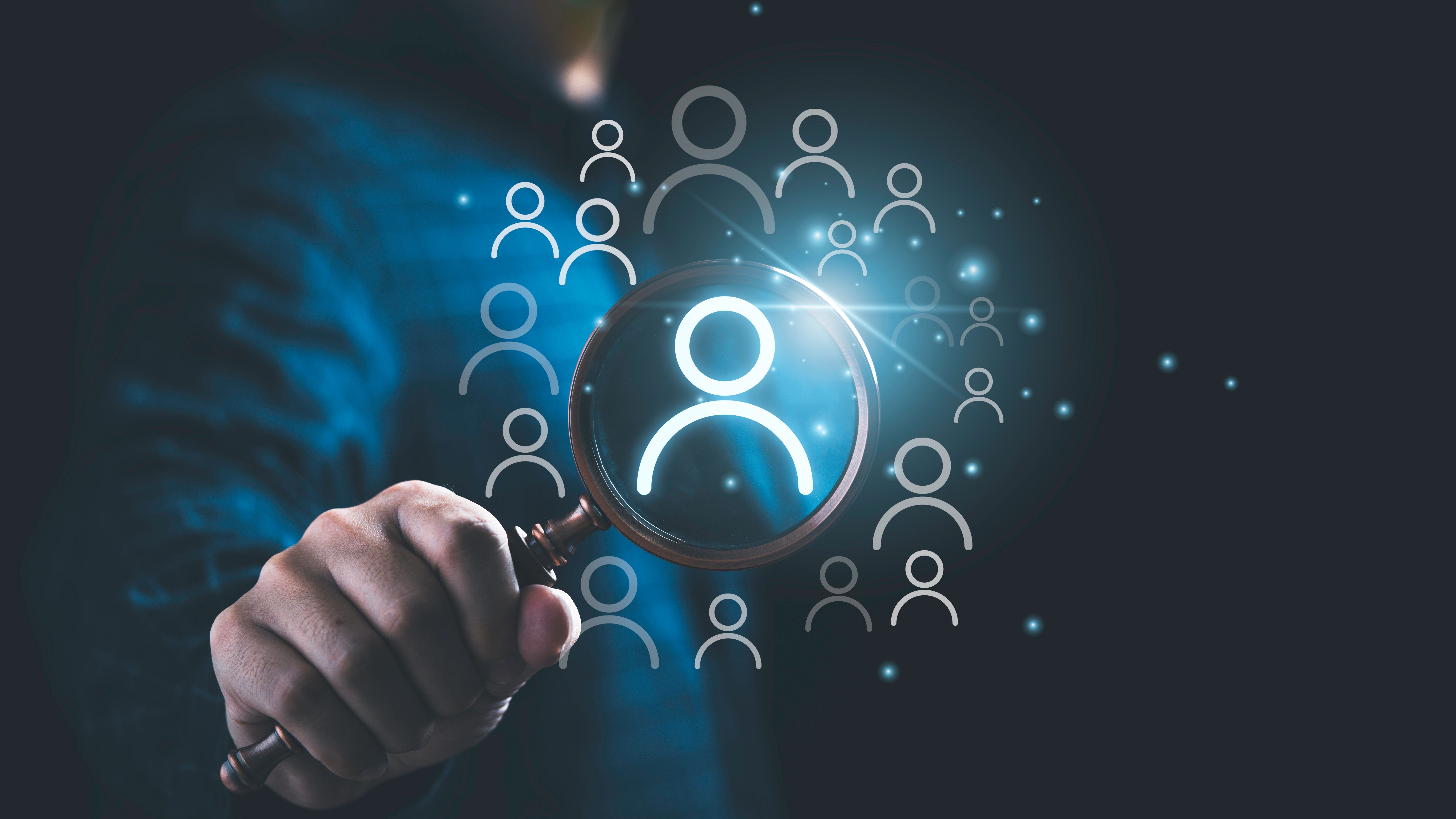 Businessman holding magnifier glass with human icons for Human Resource Management and Recruitment hiring concept.
