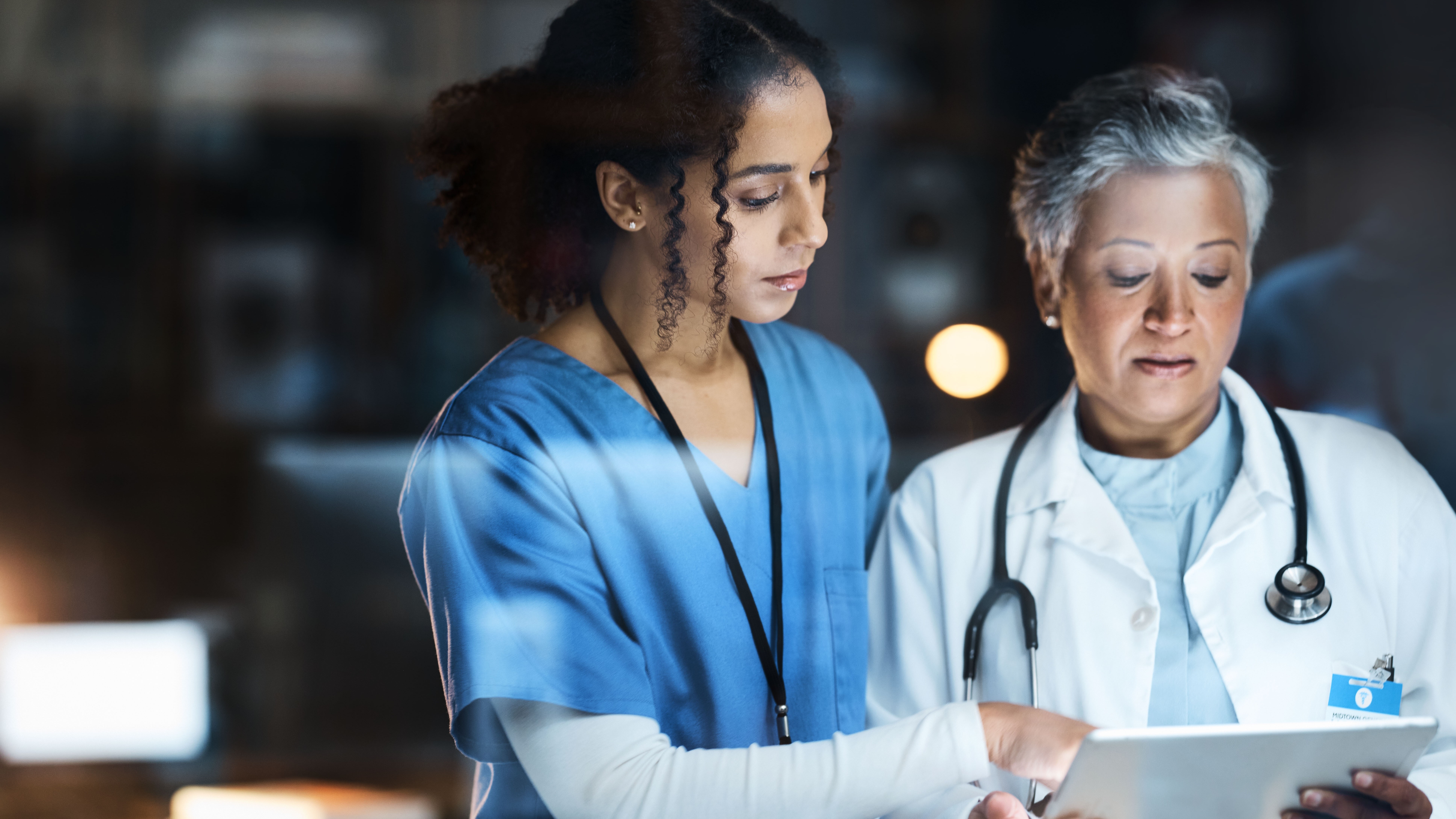 Women, doctors and tablet for night medical research, surgery planning and teamwork in hospital. Nurse, healthcare and worker collaboration on technology in late shift for wellness thinking and ideas