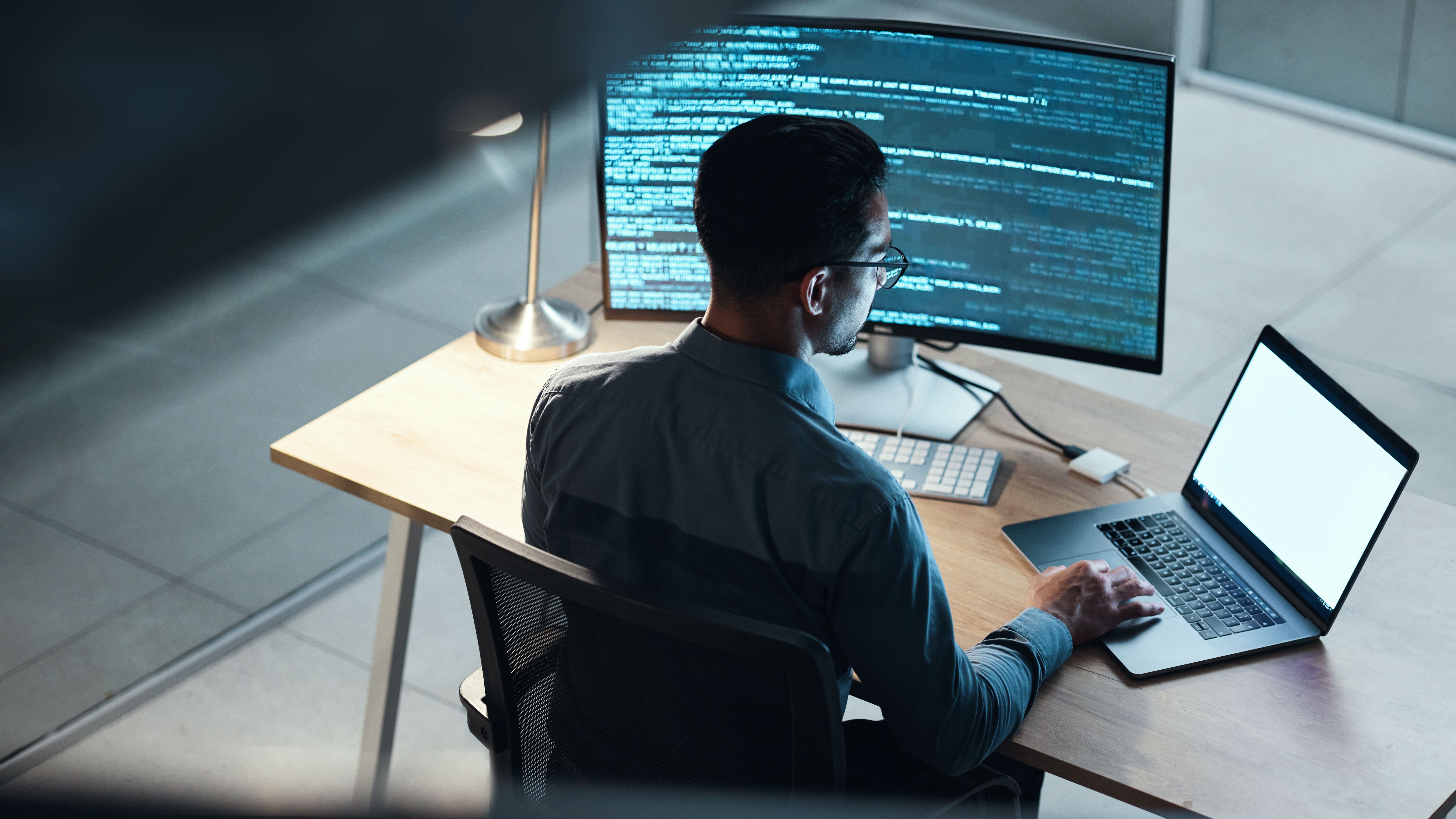 Man, programmer and coding at night on laptop mockup screen for networking, malware or software at the office. 