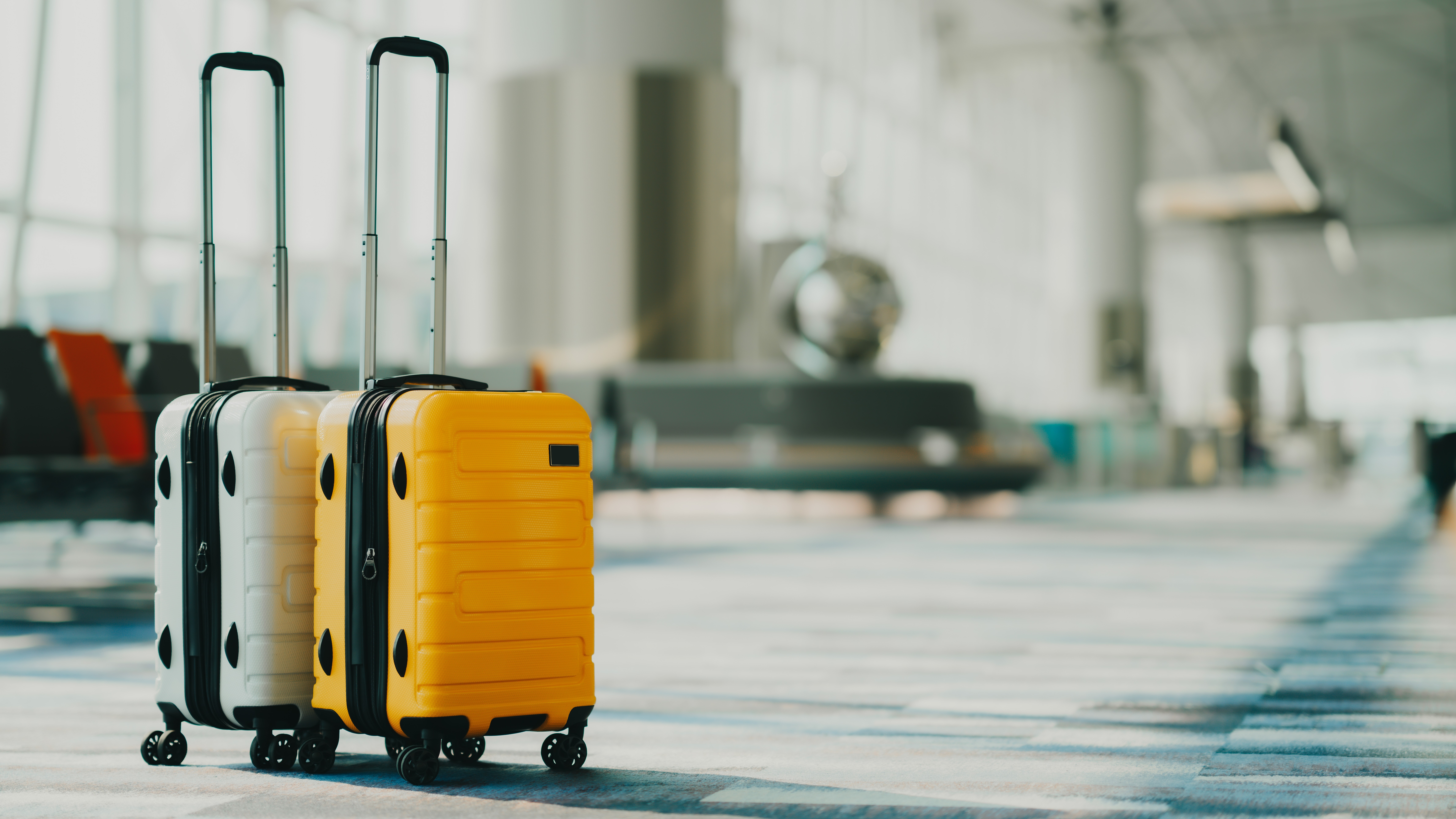 Two suitcases in an empty airport hall, traveler cases in the departure airport terminal waiting for the area, vacation concept, blank space for text message or design