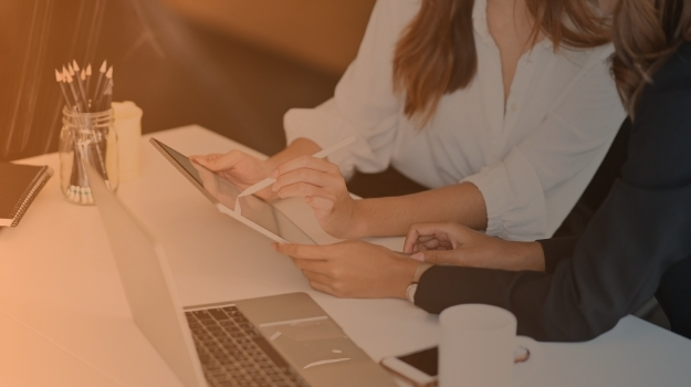 Cropped shot of woman while giving a consult to businesswoman next to her by tablet
