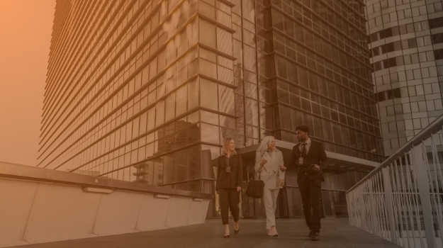 Diverse business team walking and discussing outside modern office building