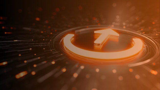 Illuminated power button with upward arrow on circuit board representing digital transformation and digitization business acceleration.